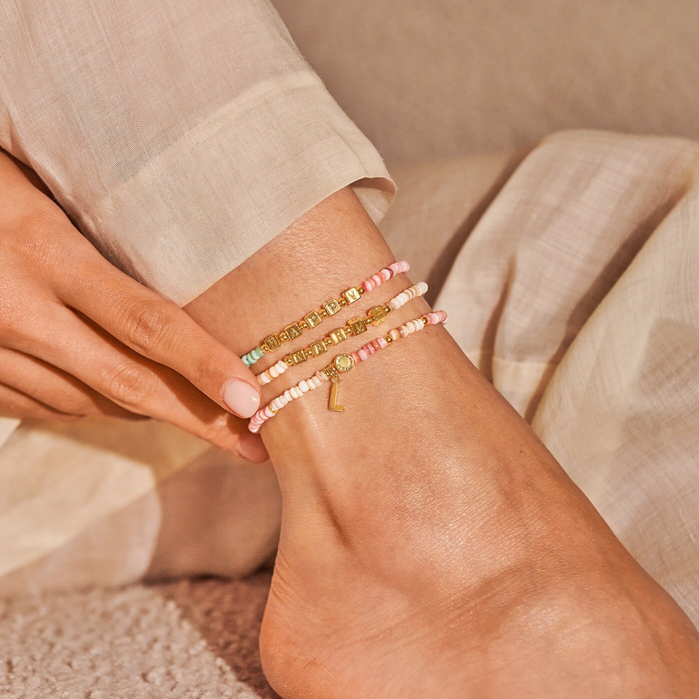 Model wearing three anklets
