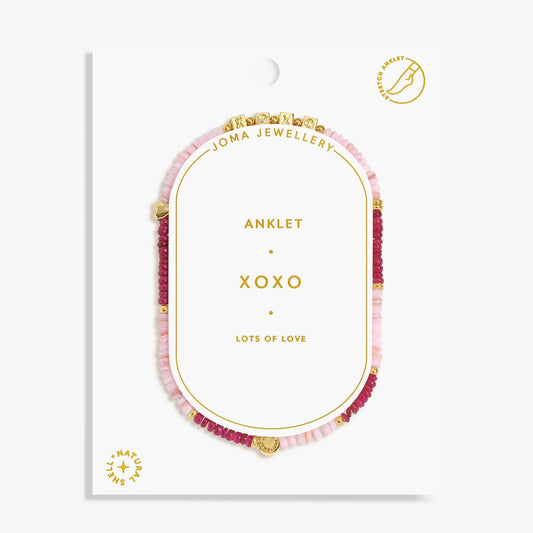 Pink beaded anklet on a white display card