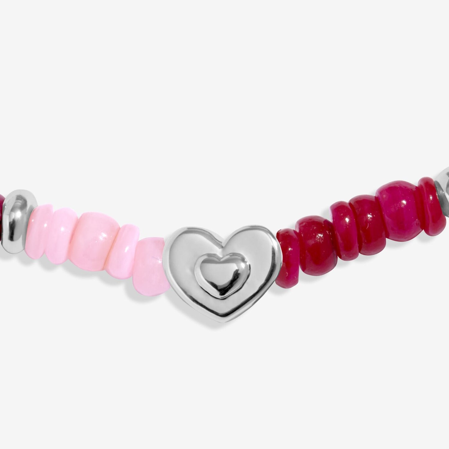 Bracelet with pink and red beads and a silver heart charm on a white background