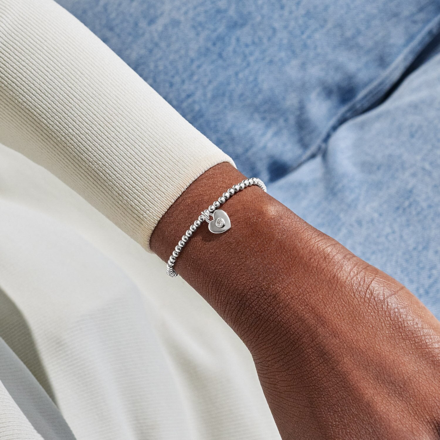 Silver bracelet on a wrist with a blurred background