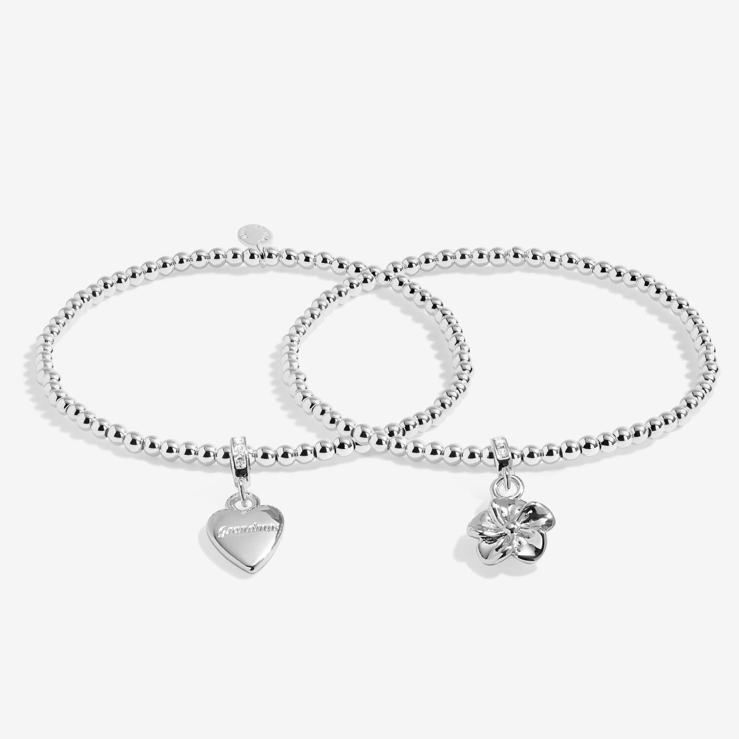 Two silver bracelets with heart and clover charms on a white background