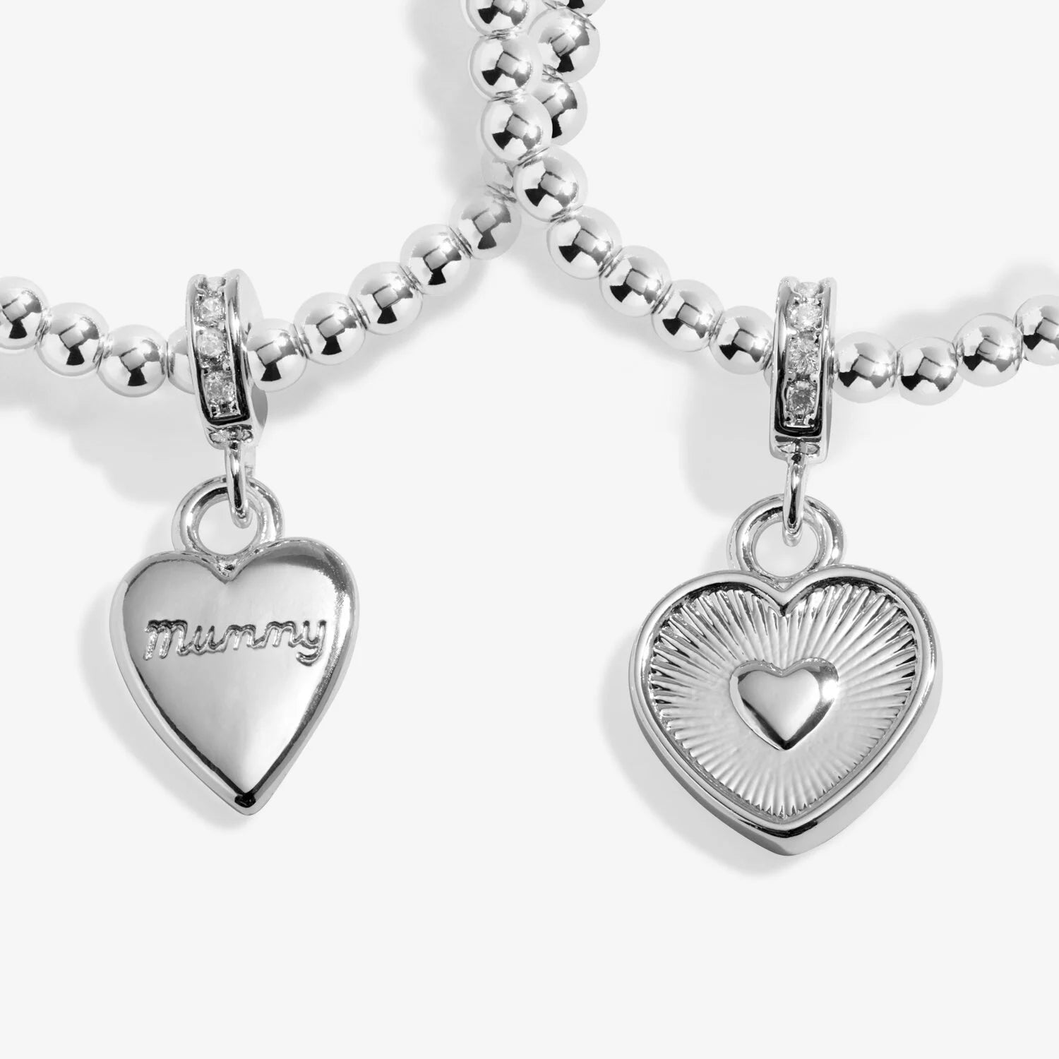 Two silver heart-shaped charms on a white background