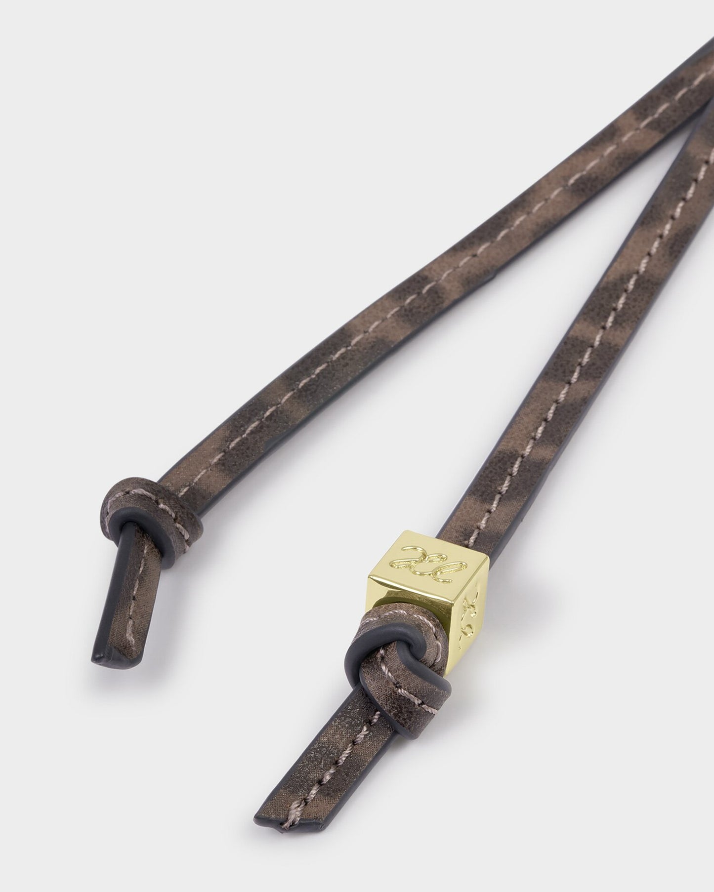 Brown leather strap with a gold tag on a white background