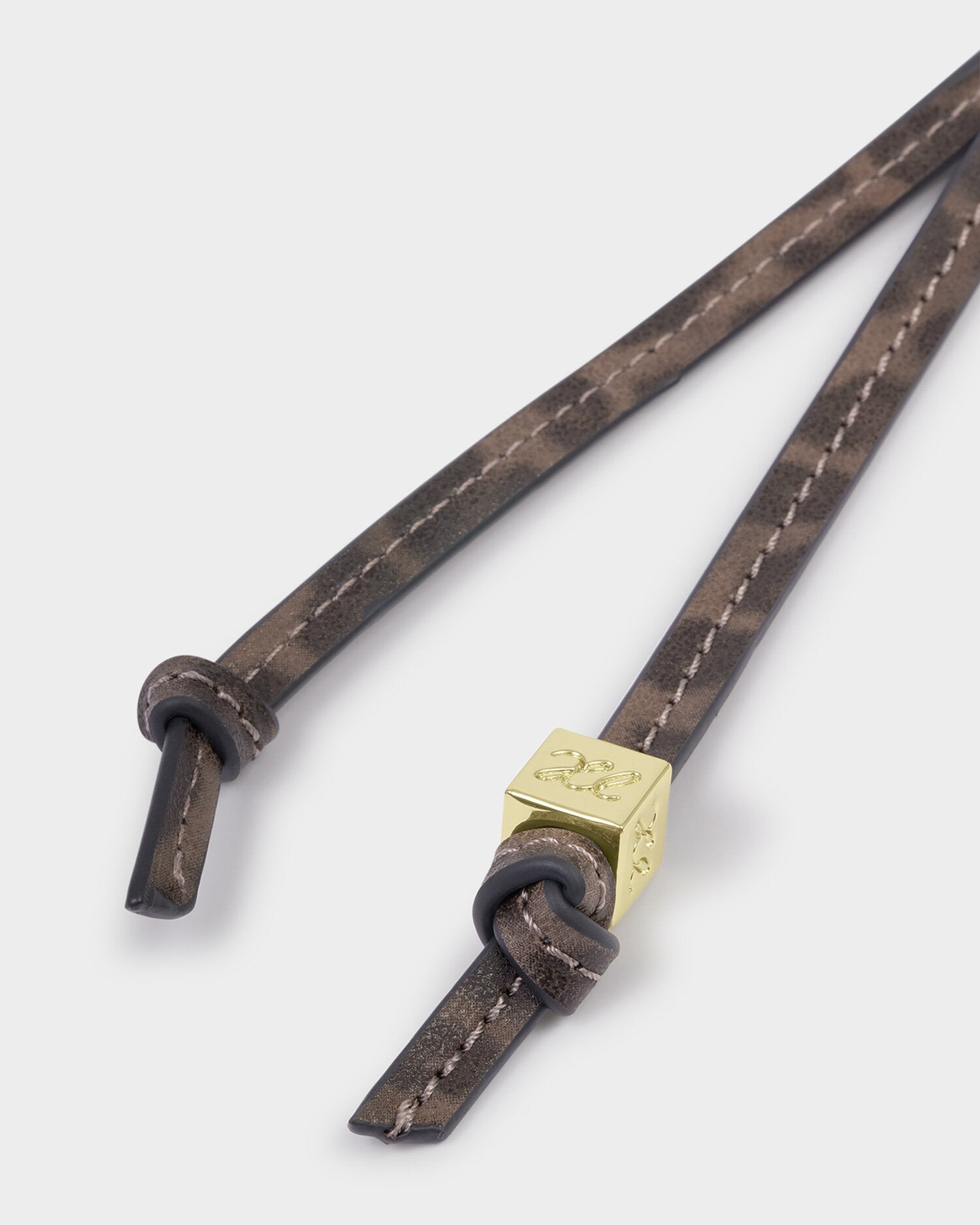 Brown leather strap with a gold tag on a white background