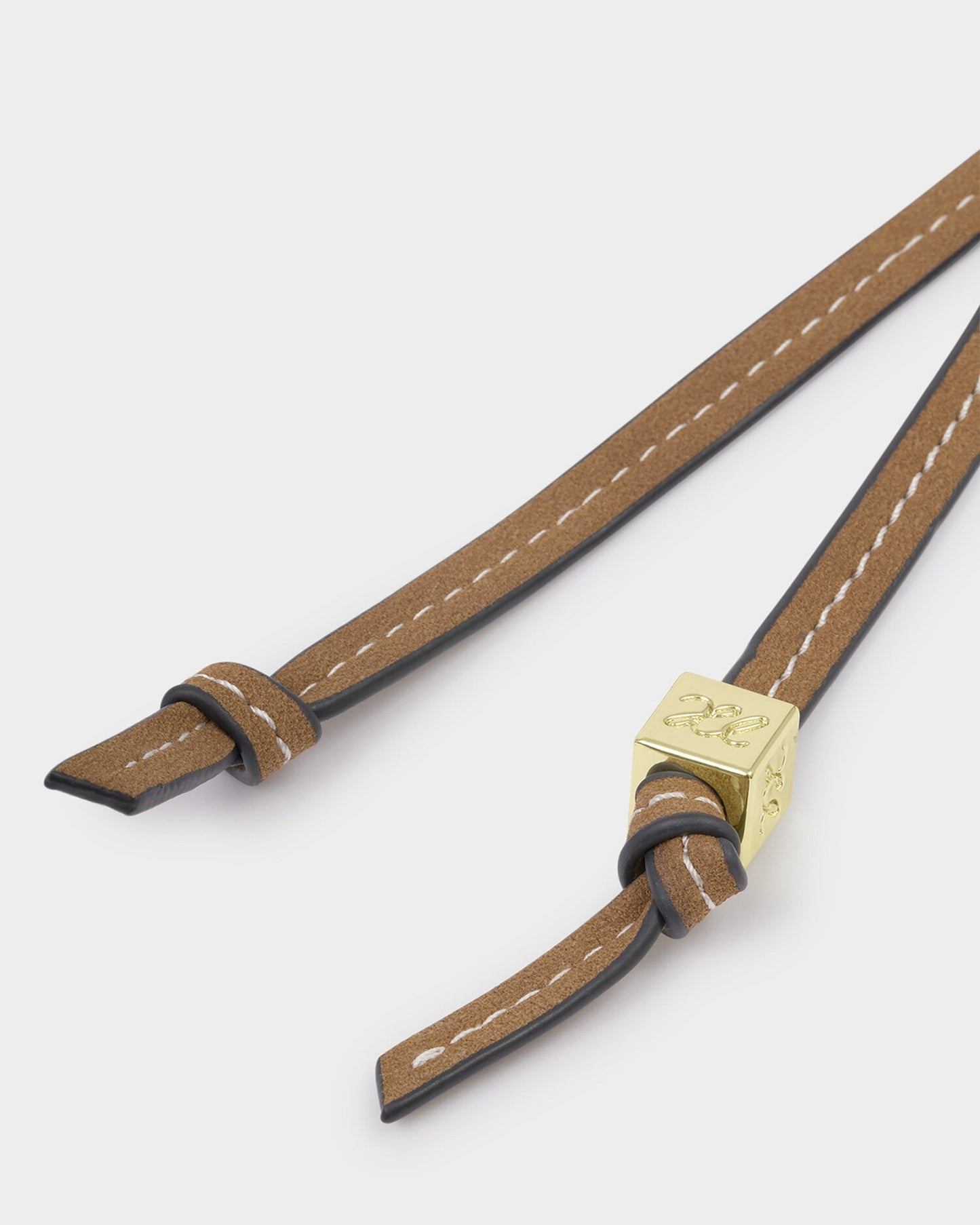 Brown leather strap with gold buckle on a white background