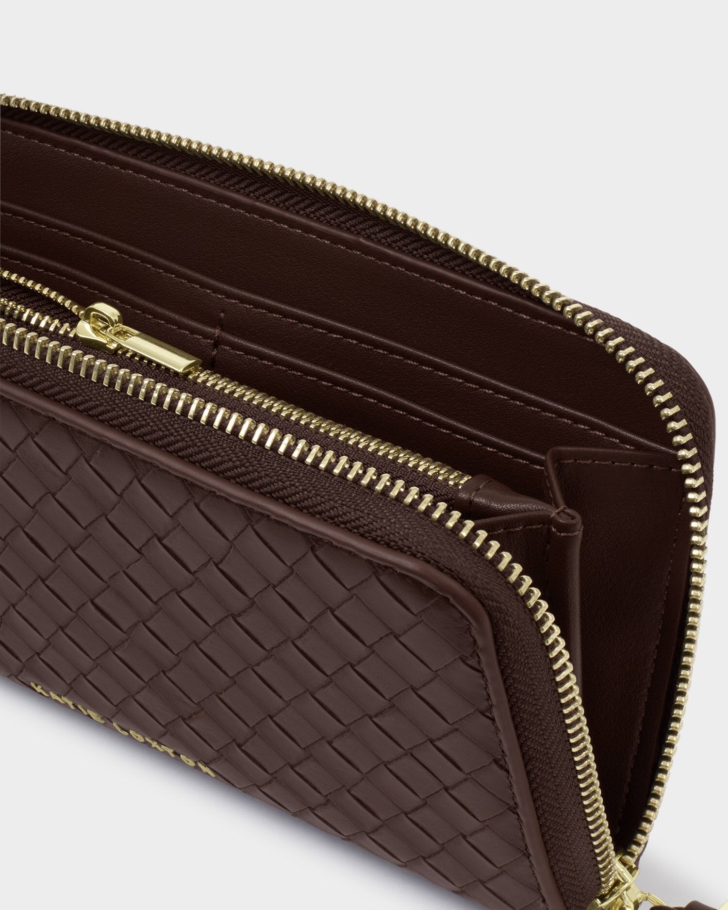 Brown woven wallet with gold zipper on a light gray background