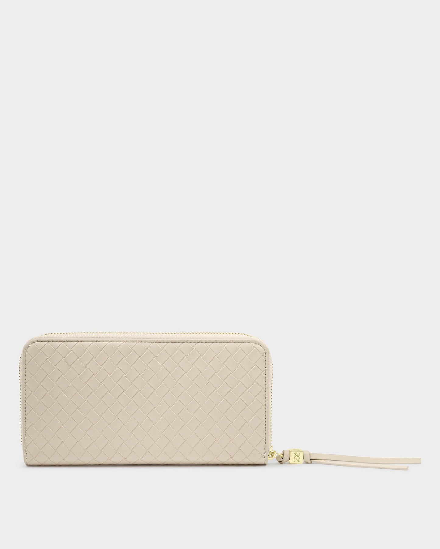 Beige quilted wallet with a gold zipper on a light gray background