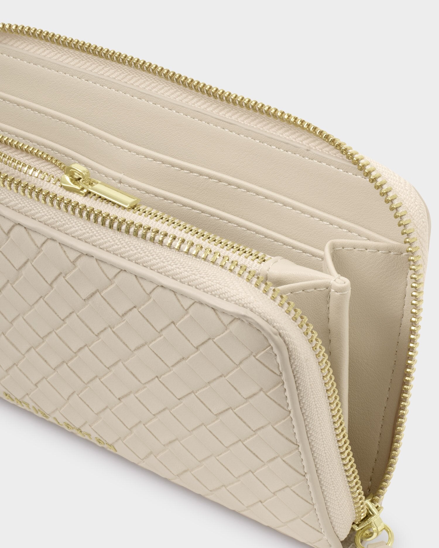 Beige wallet with gold zipper on a light gray background