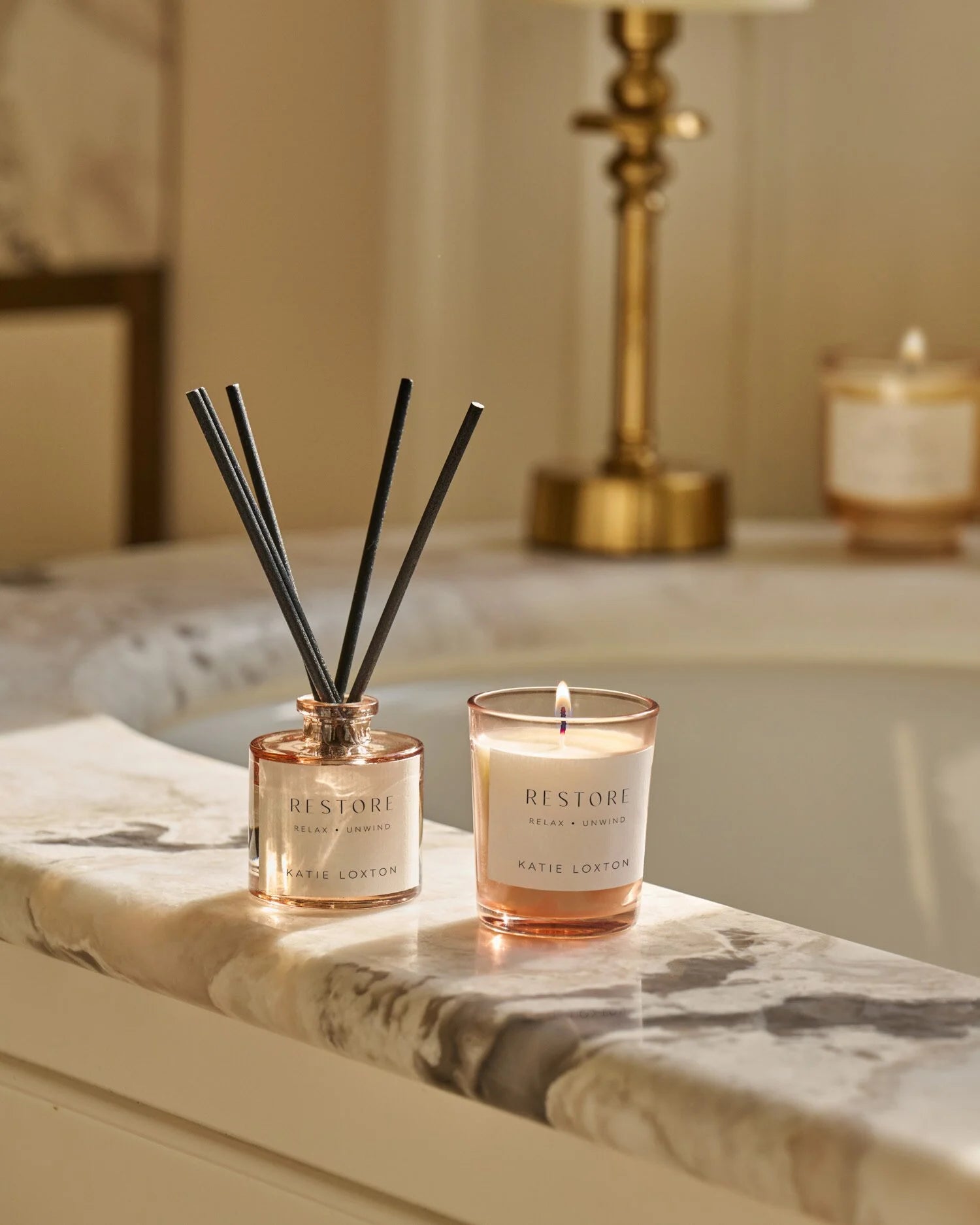RESTORE diffuser and candle on a marble surface with a blurred background