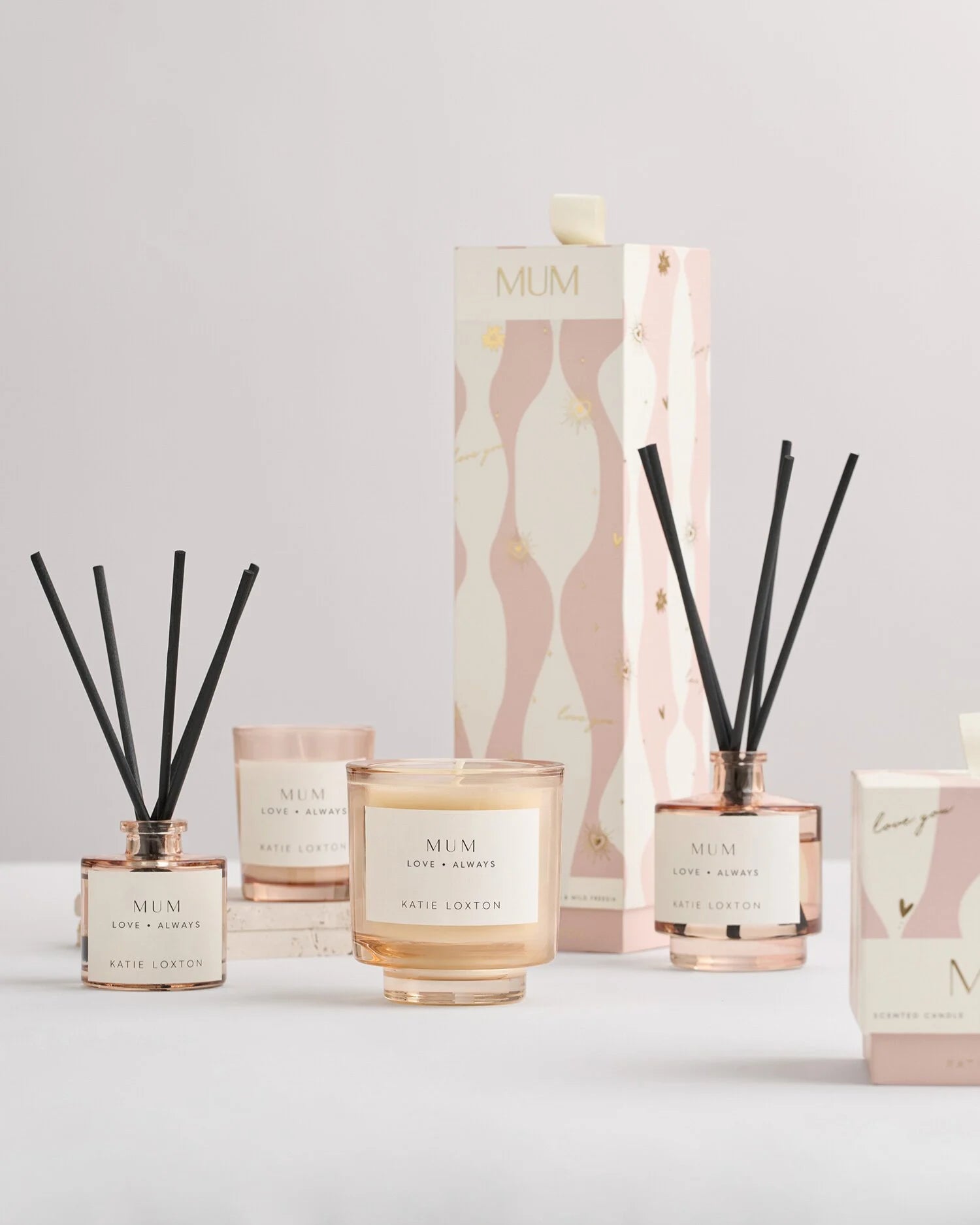 Collection of 'Mum' themed candles and diffusers on a light background