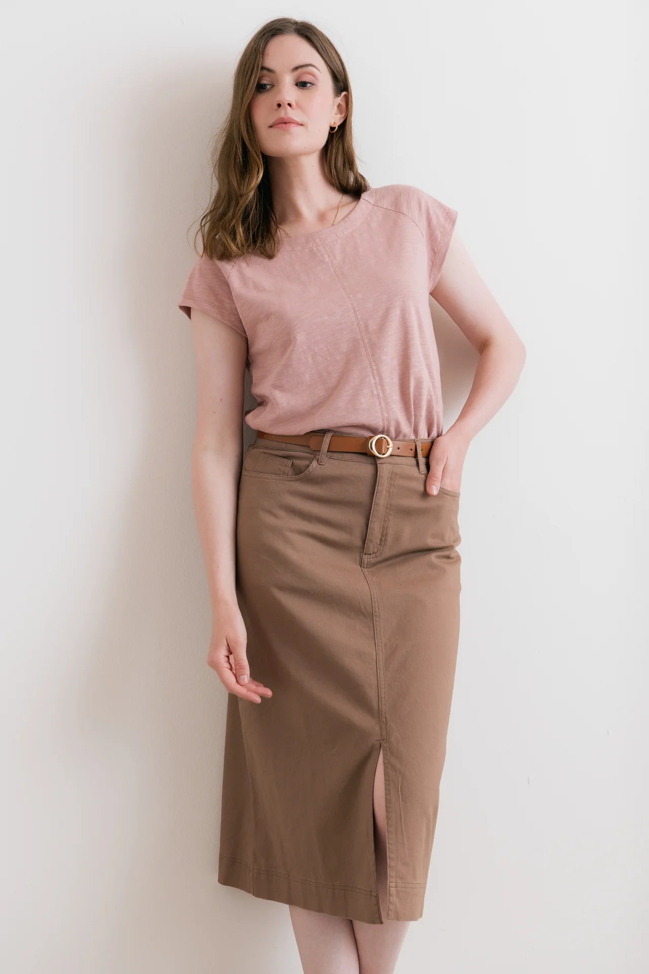 Model wearing pink t-shirt with brown skirt