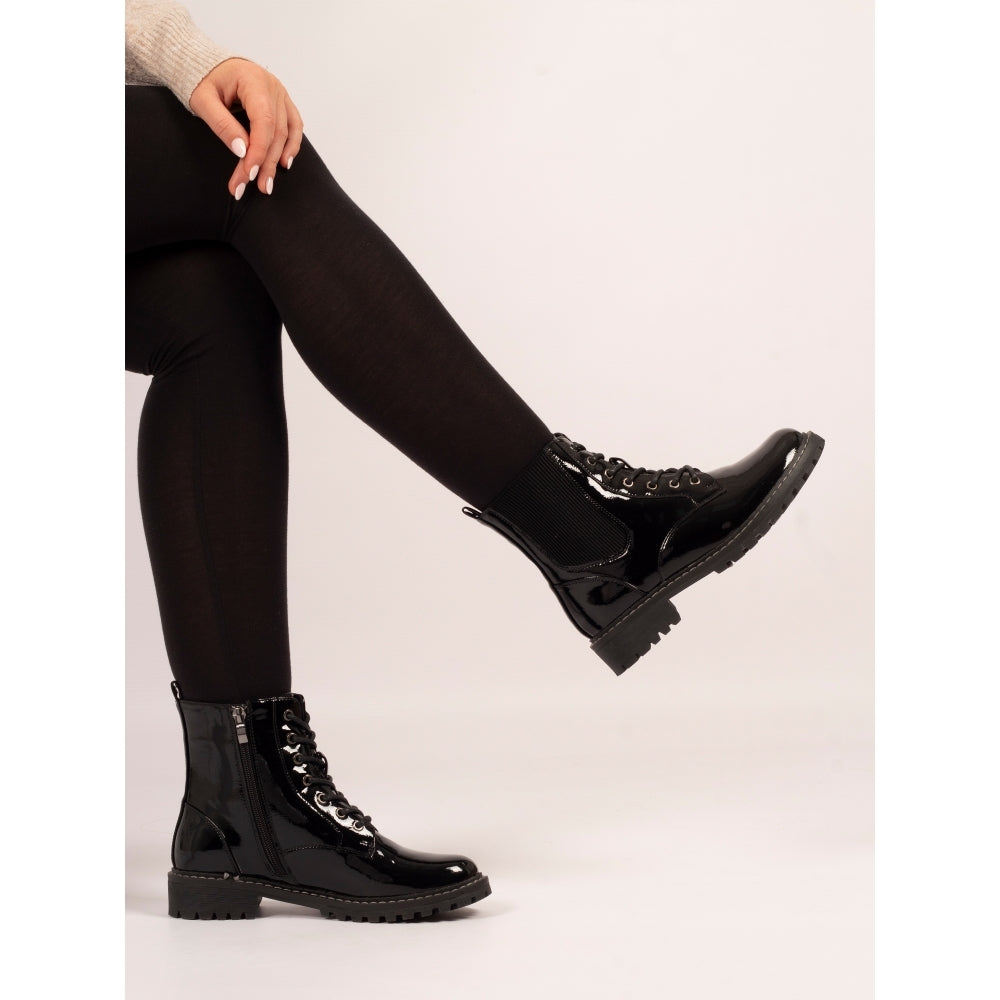 Black boots worn with black tights on a white background