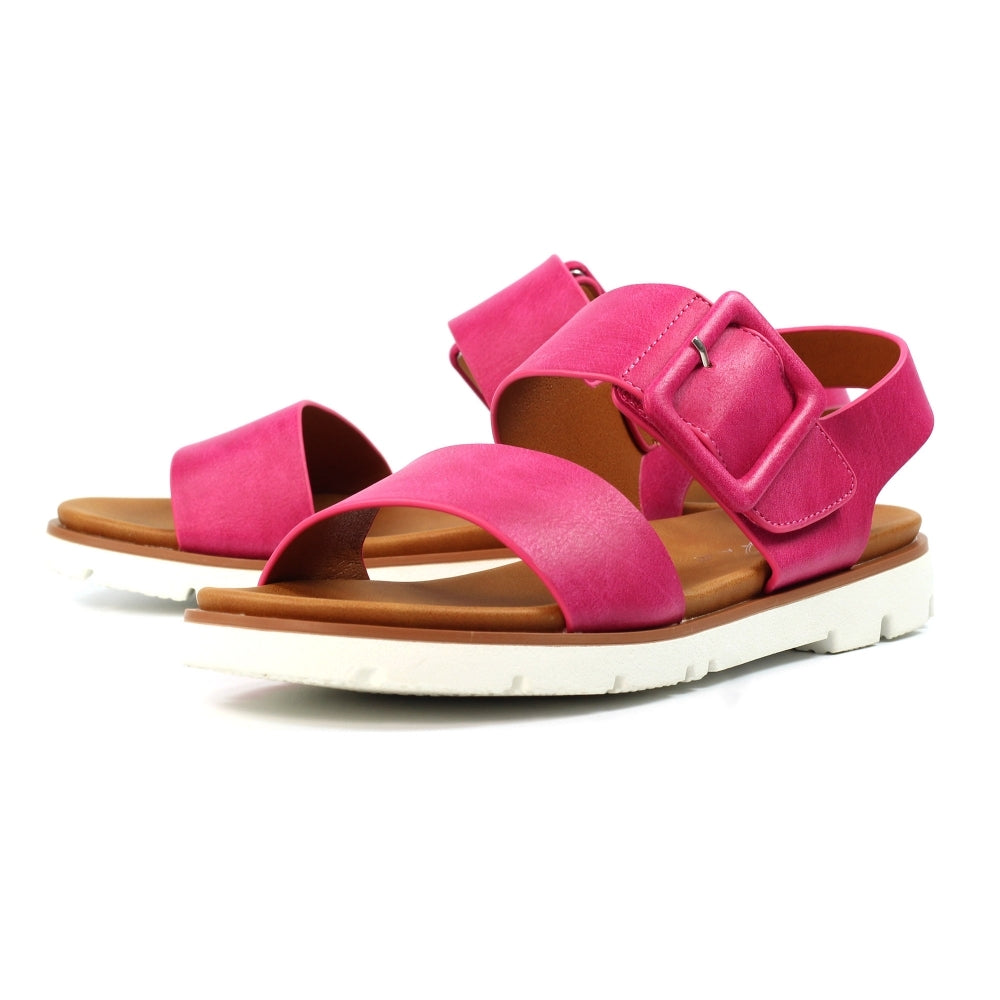 Pair of pink sandals with brown soles on a white background