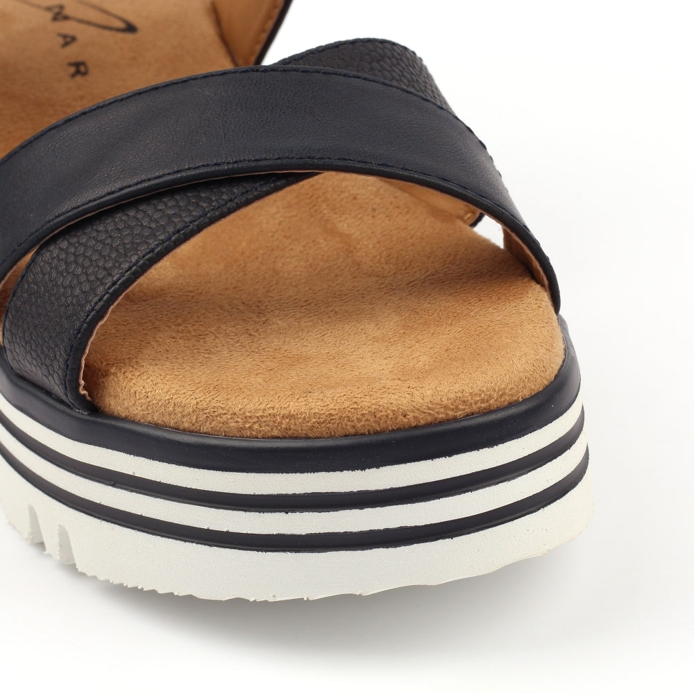 Navy sandal with brown sole and white sole with black stripes on a white background