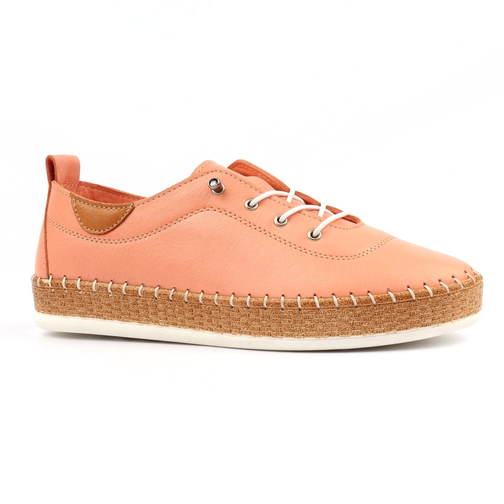 Peach-colored sneaker with a cork sole on a white background