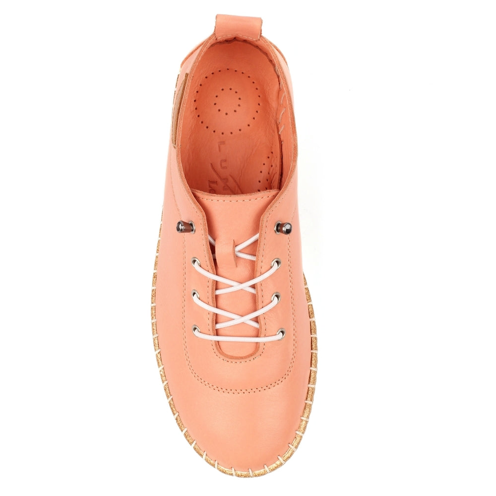 Peach-colored sneaker with white laces on a white background