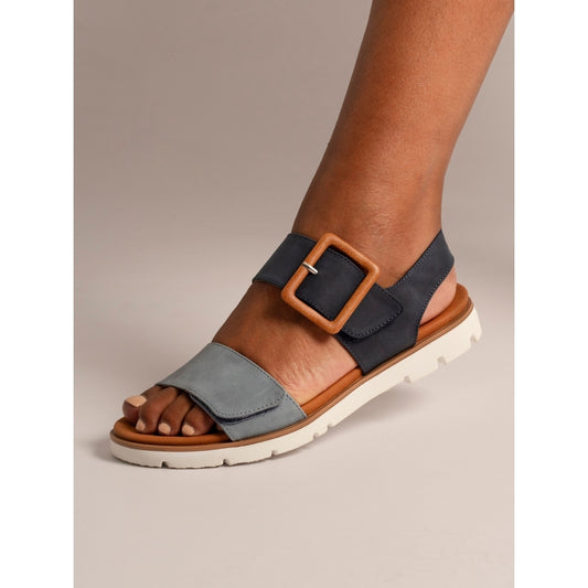Blue sandal with brown buckle on a neutral background