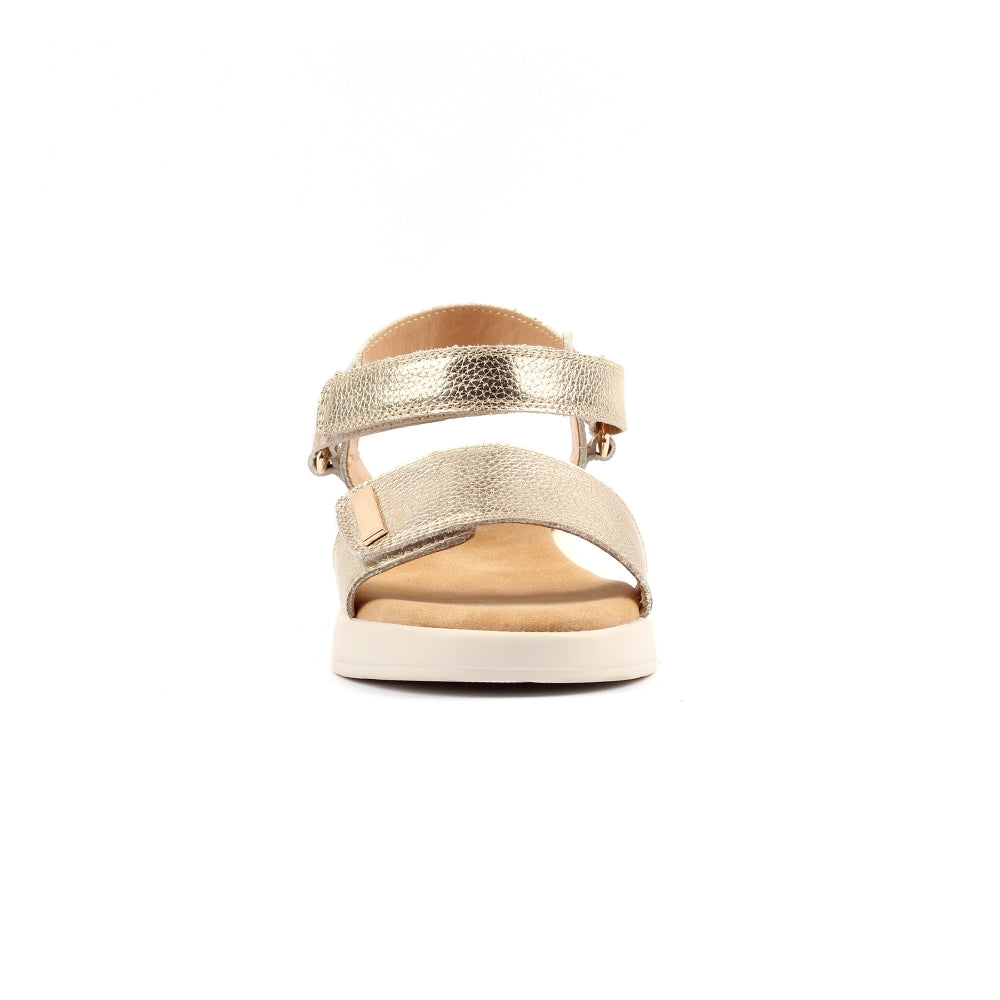 Gold sandal with a white sole on a white background