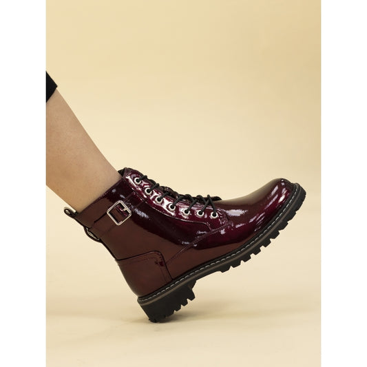 Burgundy boot with a buckle on a beige background