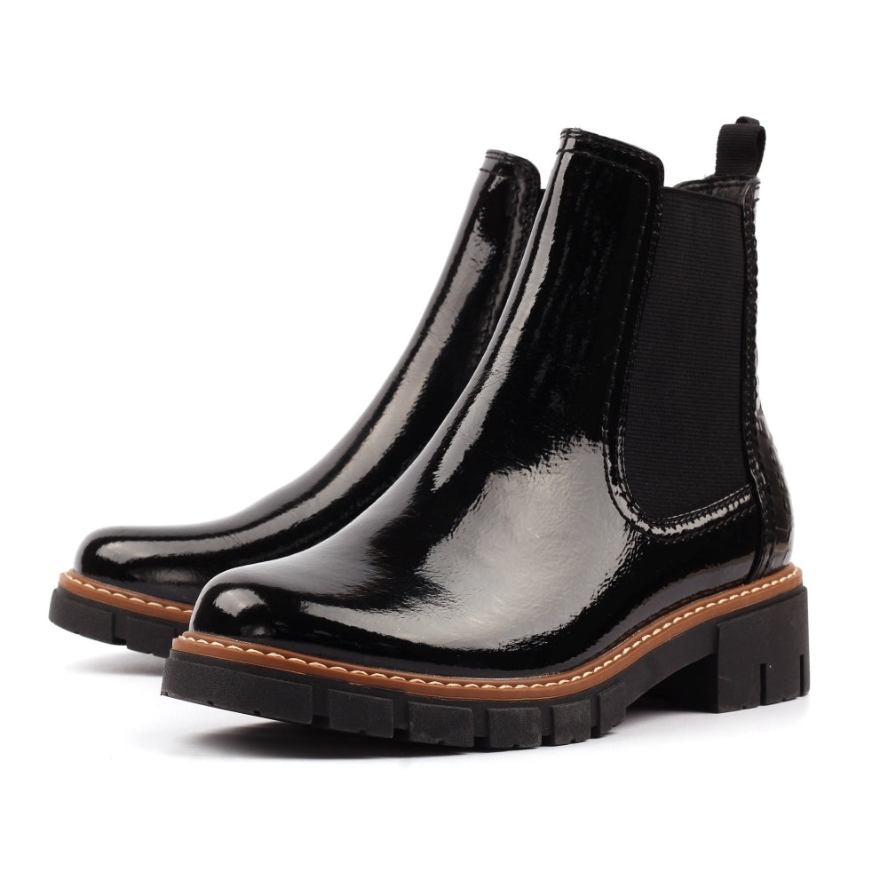 Pair of black patent leather Chelsea boots on a white background