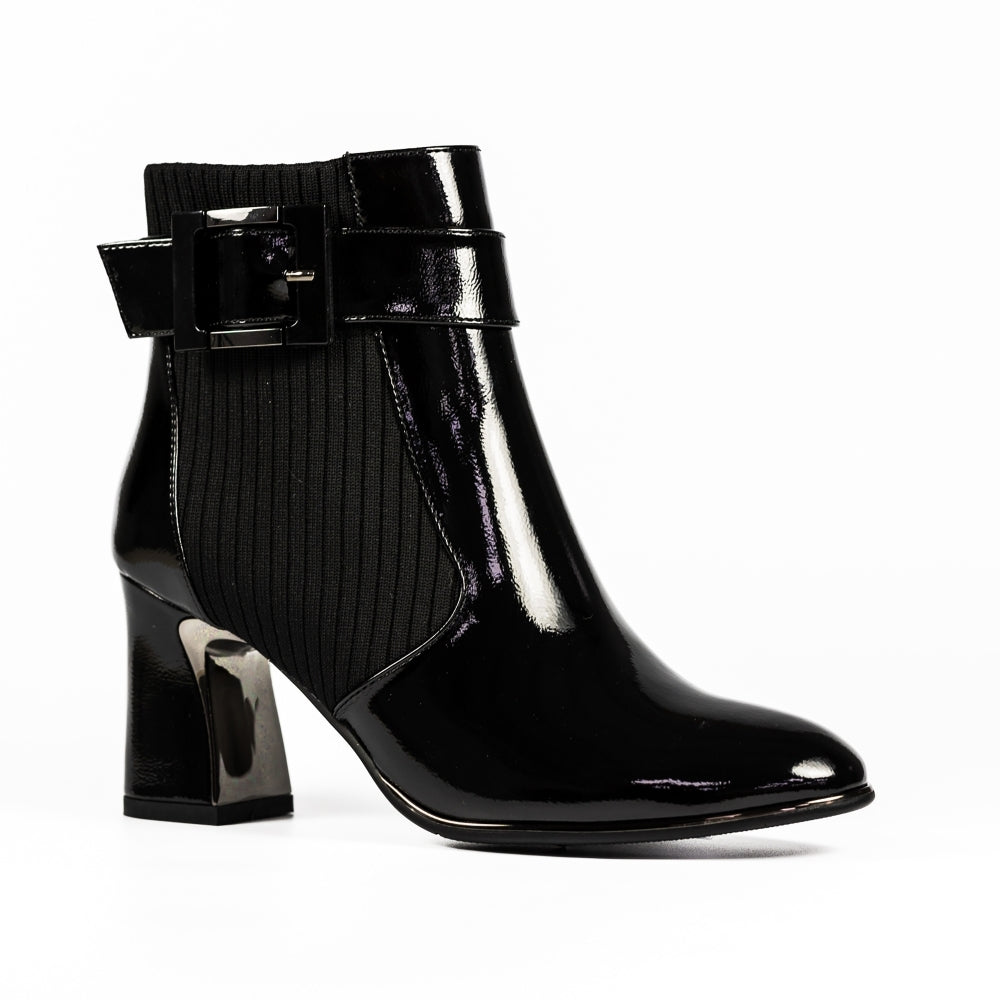 Black patent leather ankle boot with a buckle on a white background