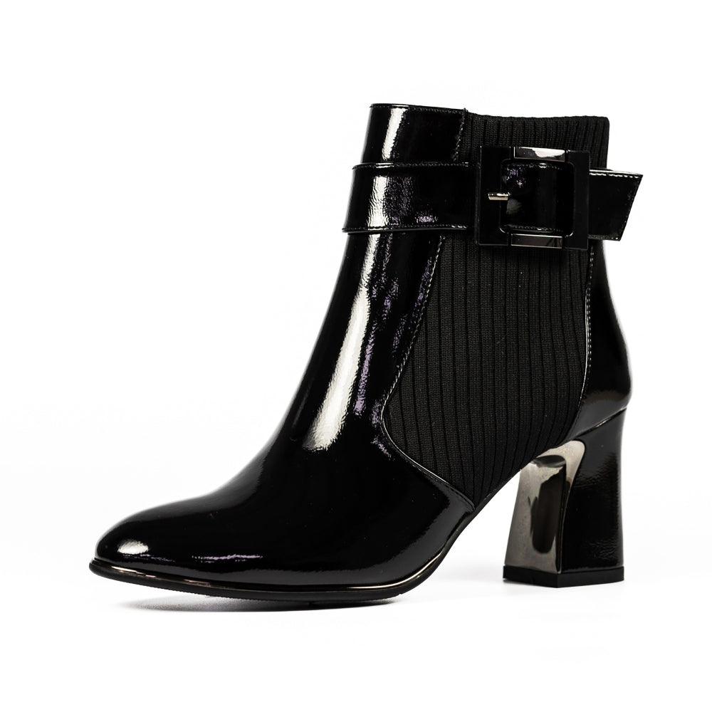 Black patent leather ankle boot with a decorative bow on a white background