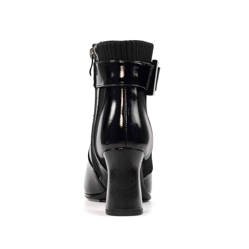 Black leather ankle boot with a buckle on a white background