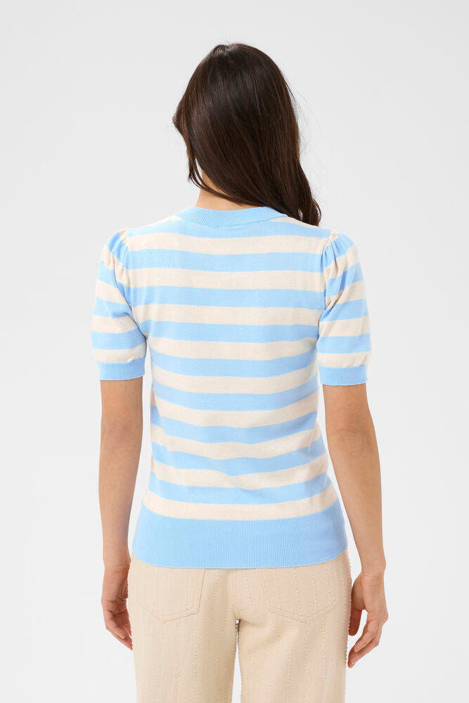 Woman wearing a light blue and beige striped sweater on a white background