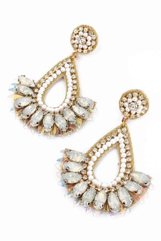 A pair of white teardrop earrings with gold detailing and small white beads, designed in a floral pattern, on a white background.