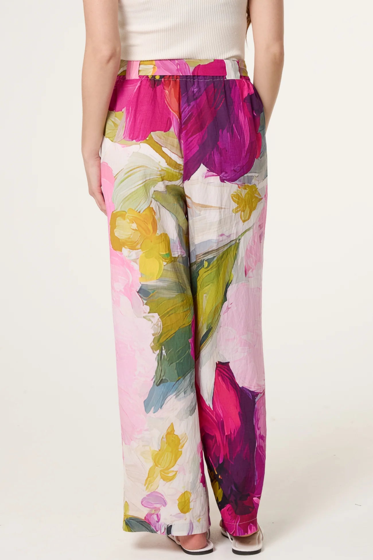 Colorful floral-patterned pants worn by a person on a white background