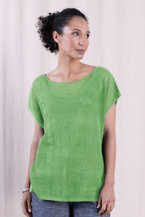 Woman wearing a green knitted top against a plain background