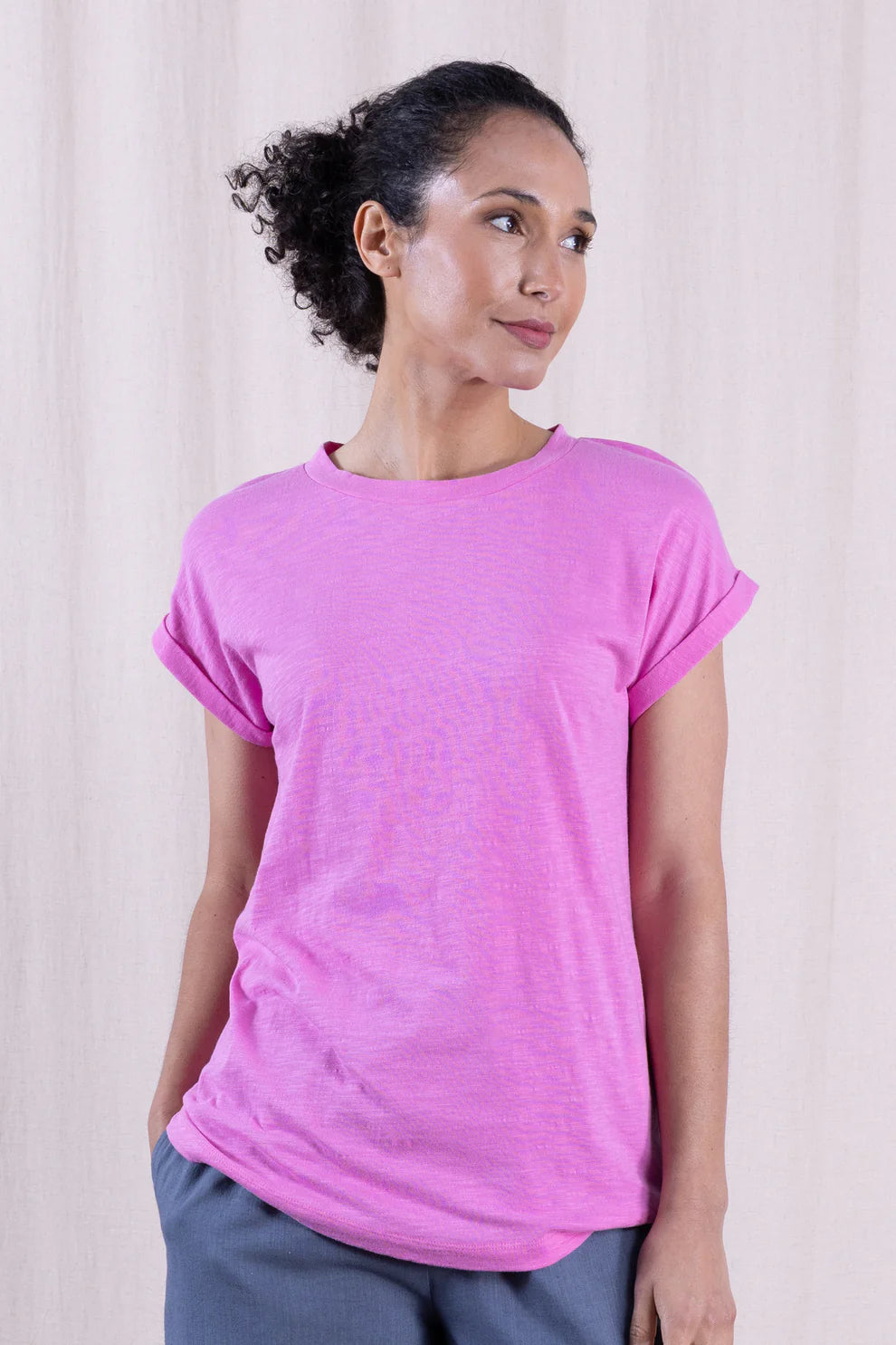 Woman wearing a pink t-shirt against a plain background