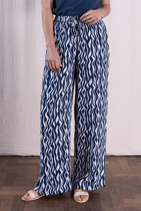 Person wearing blue and white patterned pants with a plain background