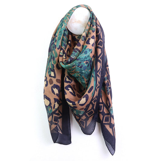 Multicolored patterned scarf on a mannequin head against a white background