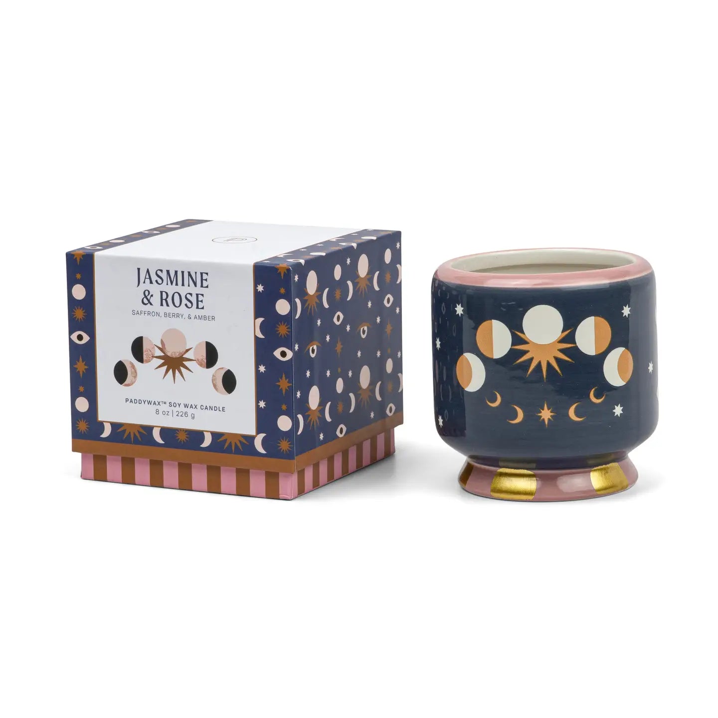 A navy blue ceramic soy wax candle with celestial moon and sun illustrations, shown next to its branded packaging box on a white background.