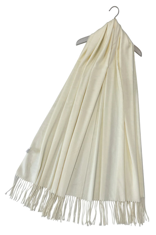 Beige scarf with fringes on a hanger against a white background