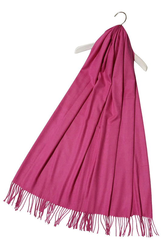 Pink scarf with fringes on a white hanger against a white background