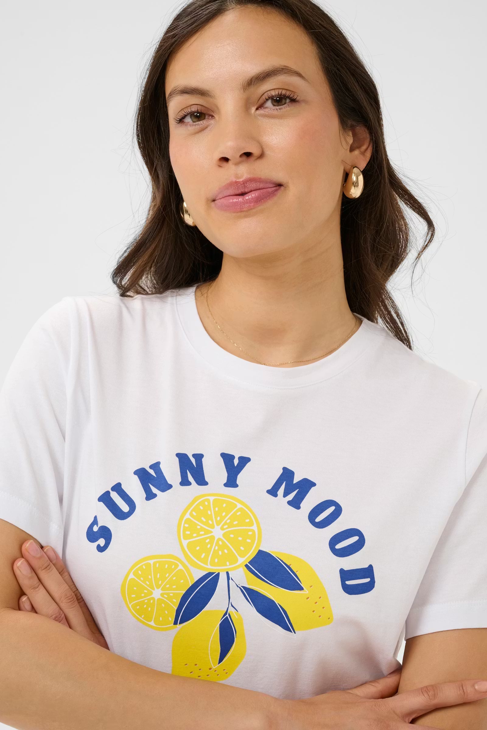 Woman wearing a white t-shirt with 'Sunny Mood' and lemon graphics.
