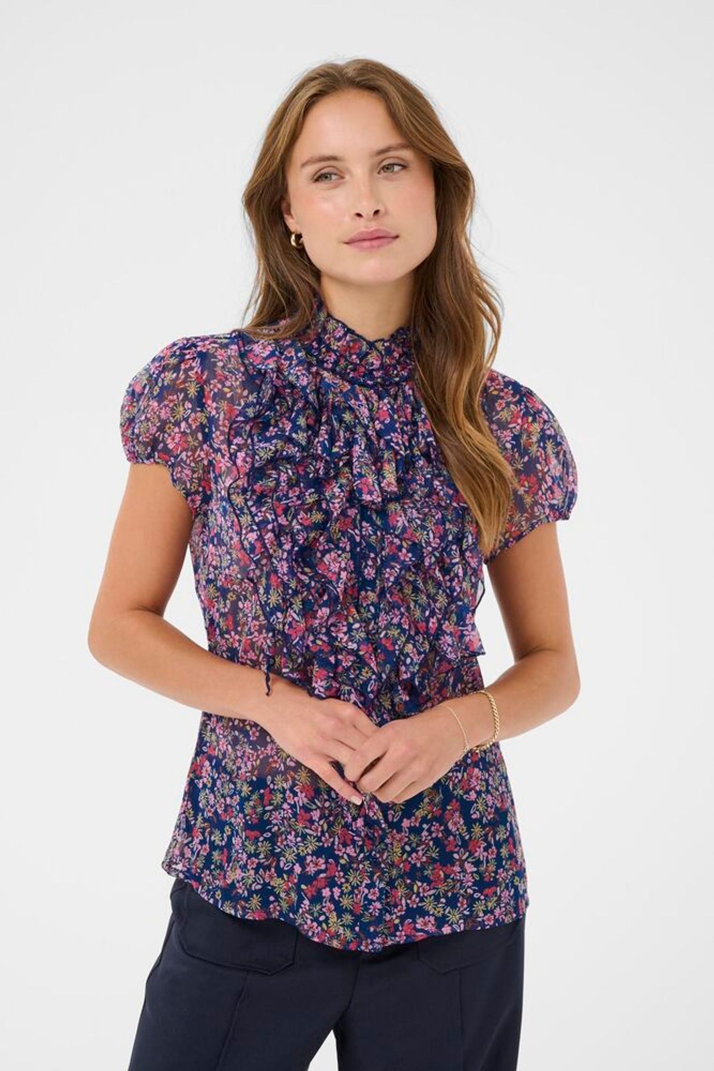Woman wearing a floral blouse with puffed sleeves on a white background