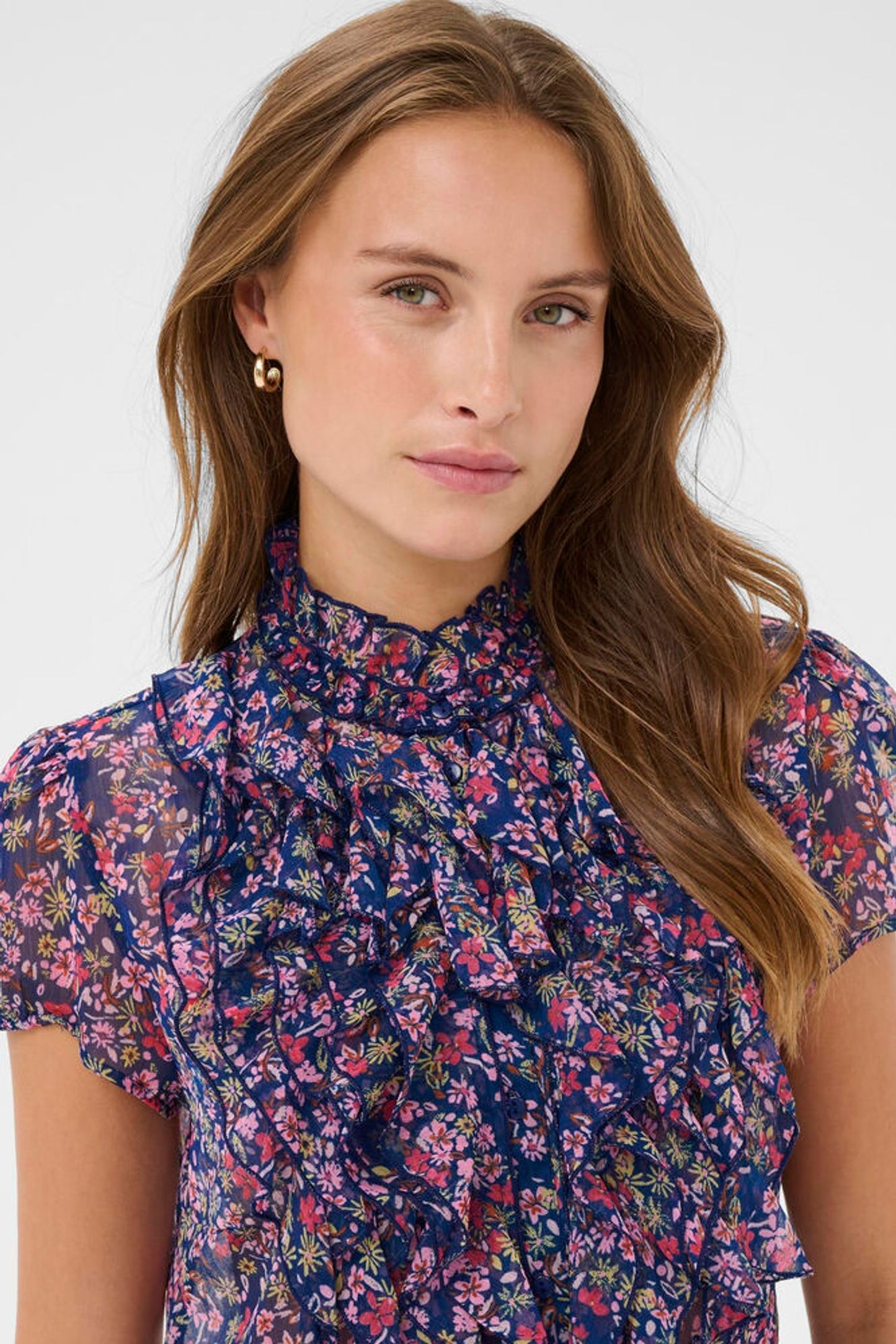 Woman wearing a floral blouse against a white background