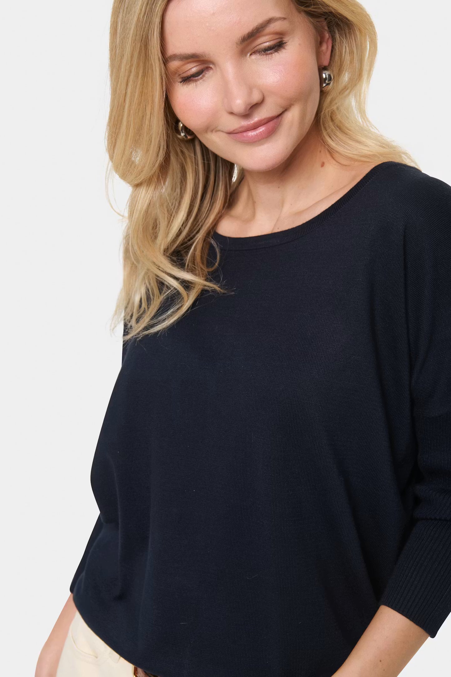 Woman wearing a navy blue sweater on a white background