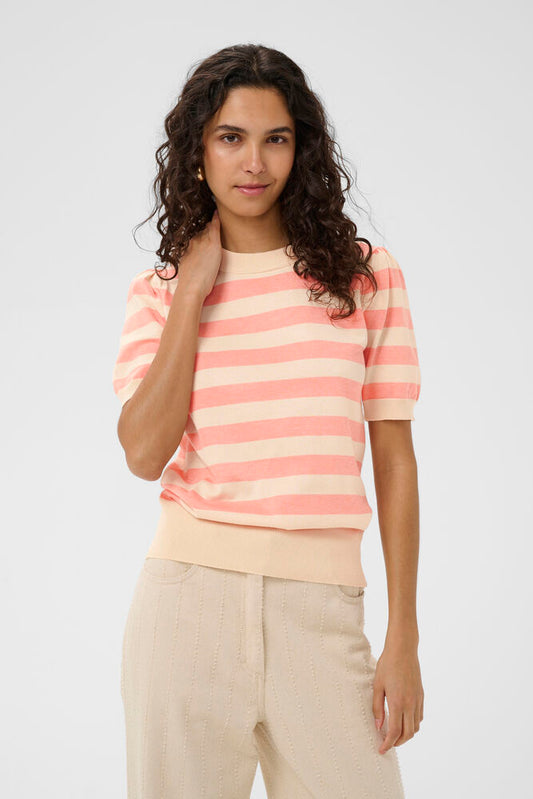 Woman wearing a pink and beige striped shirt against a plain background