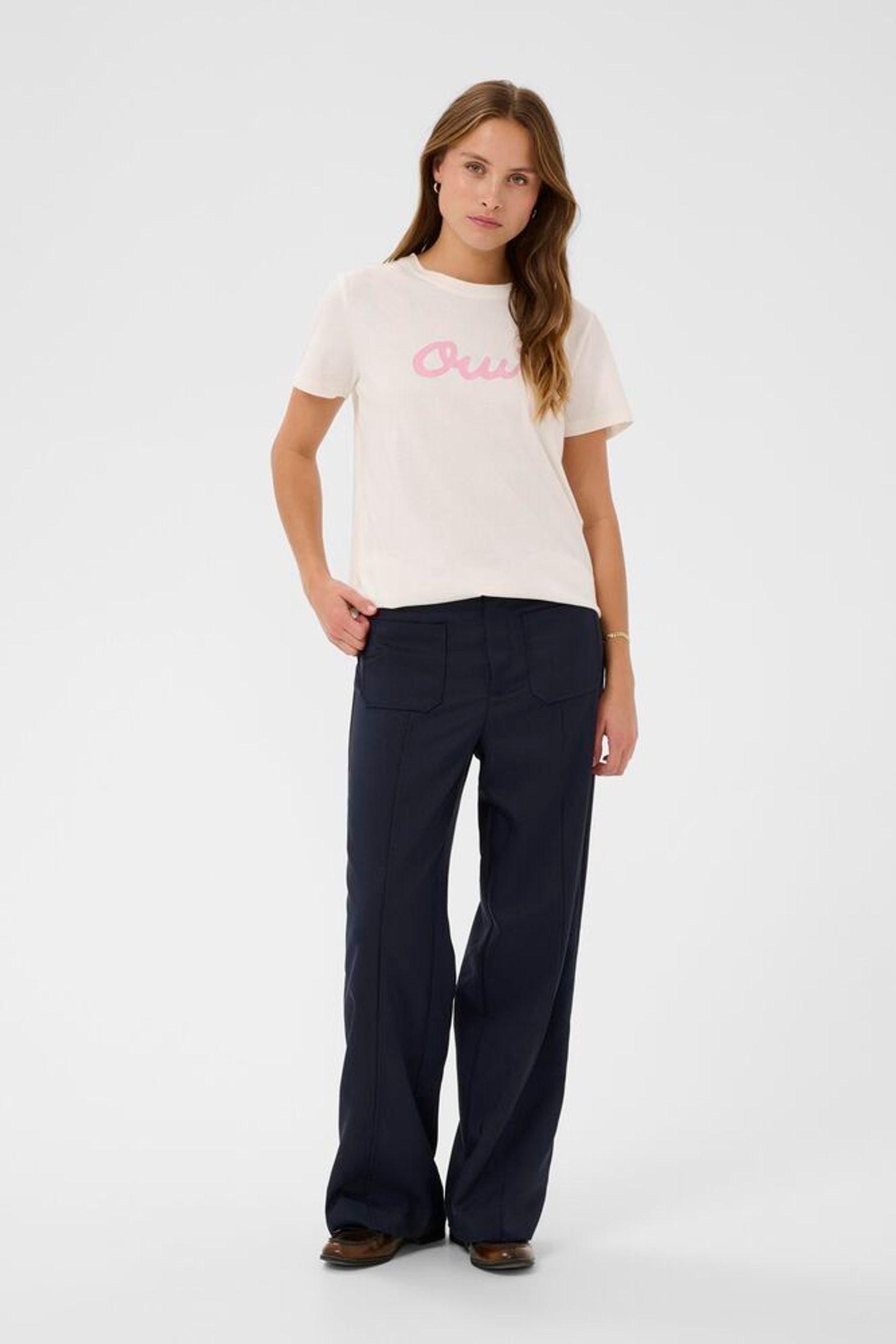 Model in navy trousers and white t-shirt