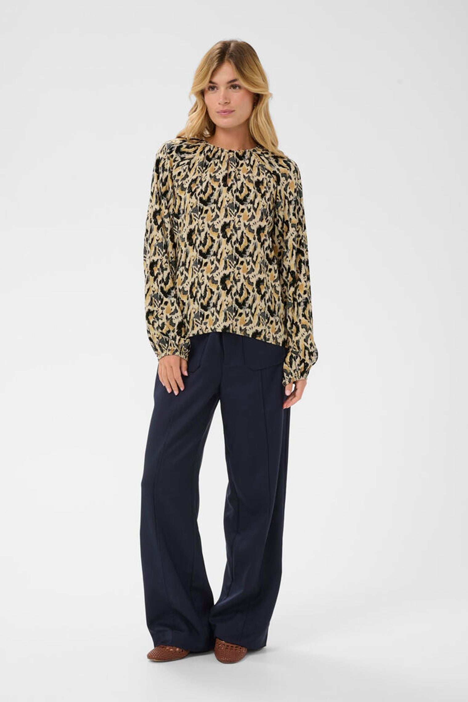 Loose fitting blouse modelled with navy trousers