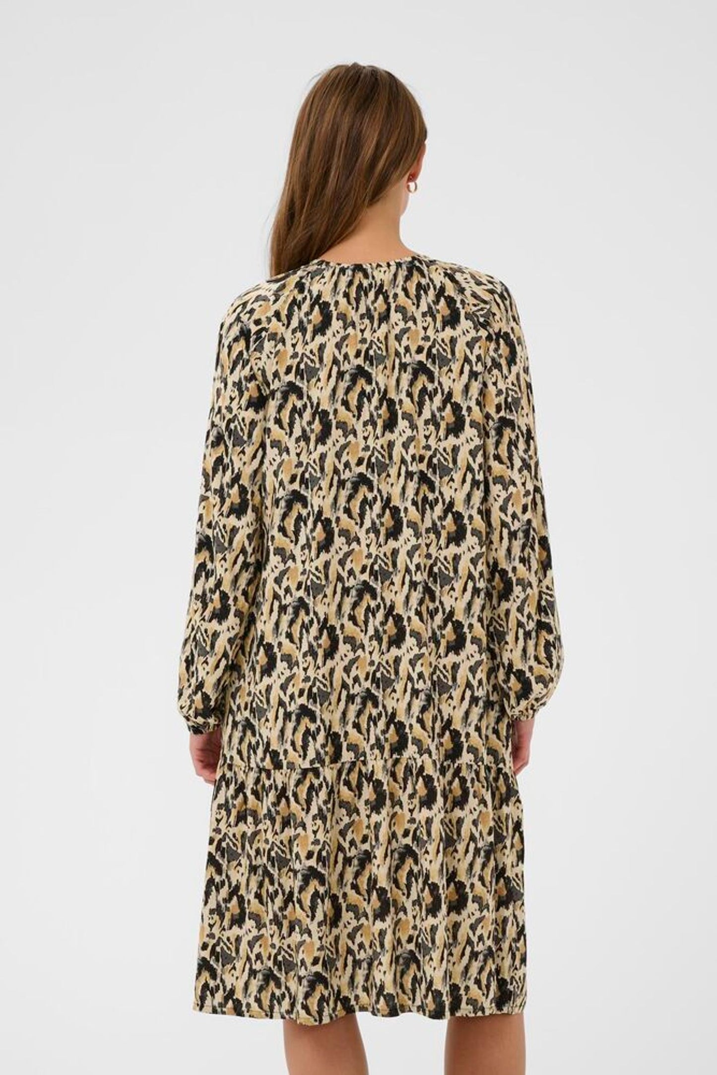 Woman wearing a leopard print dress on a white background