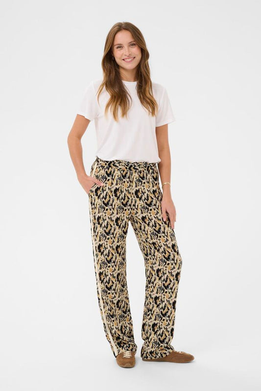 Woman wearing a white t-shirt and leopard print pants on a white background