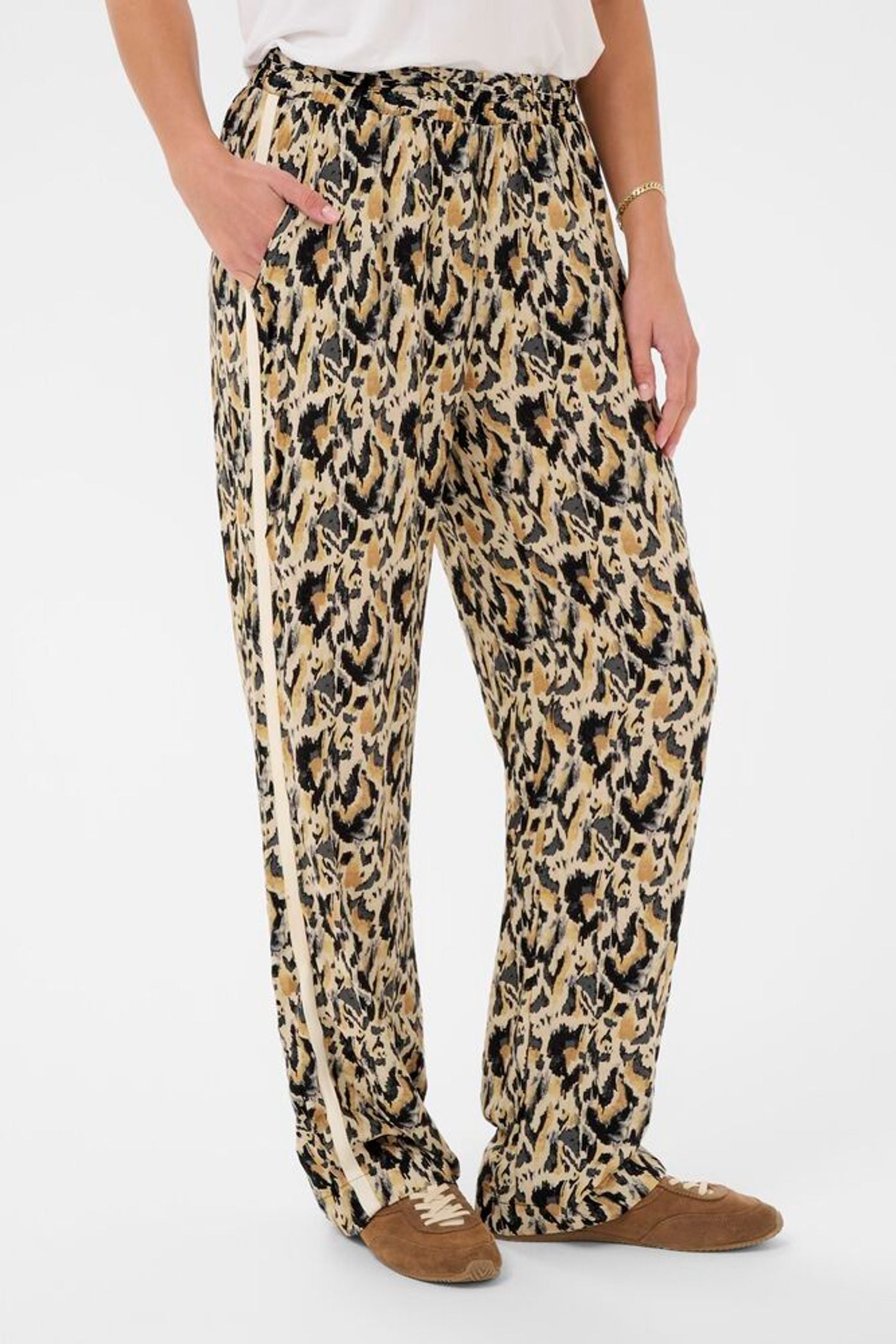 Leopard print pants worn by a person on a white background