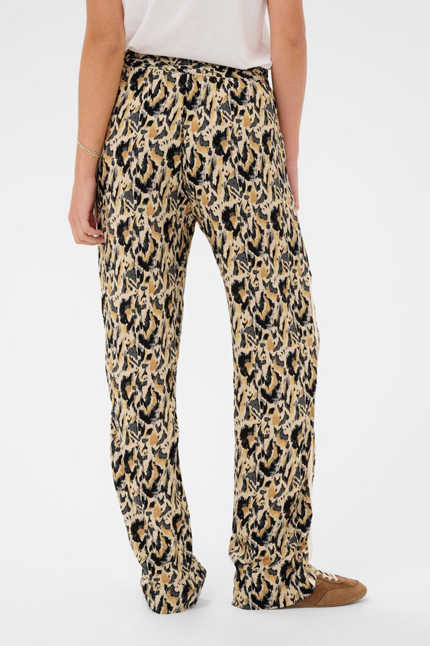 Leopard print pants worn by a person on a white background