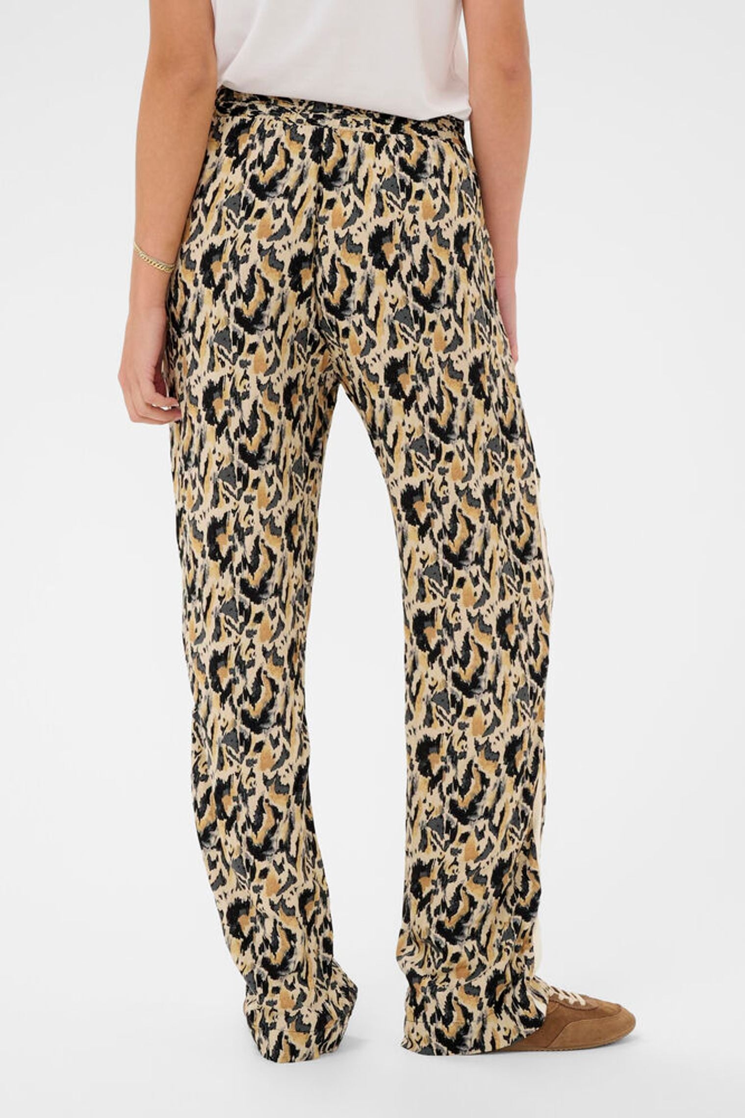 Leopard print pants worn by a person on a white background