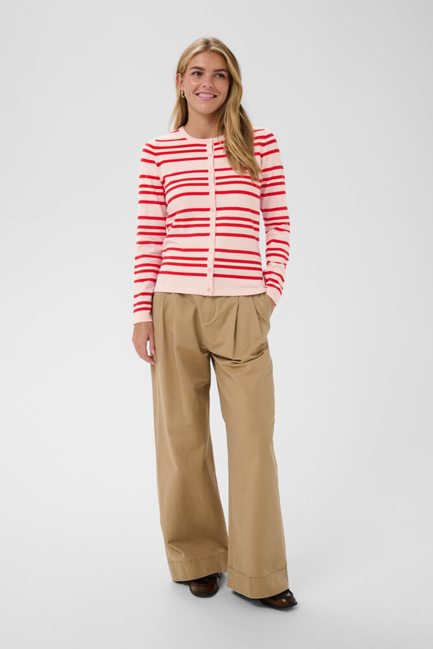 Model wearing pink cardigan with red stripes